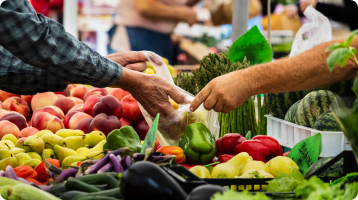 People exchanging fresh produce at a market