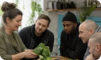 Group examining freshly harvested vegetables together
