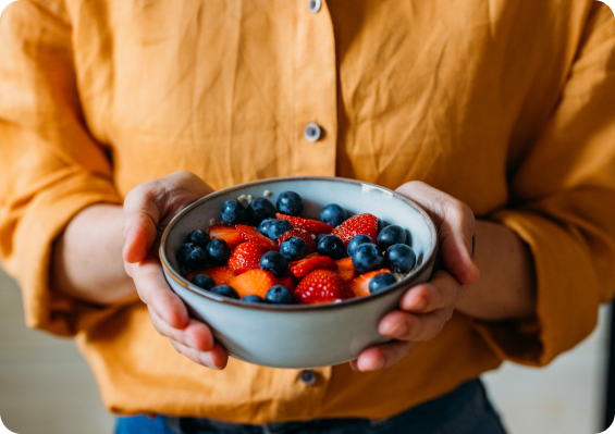 Person holding a bowl of mixed berries