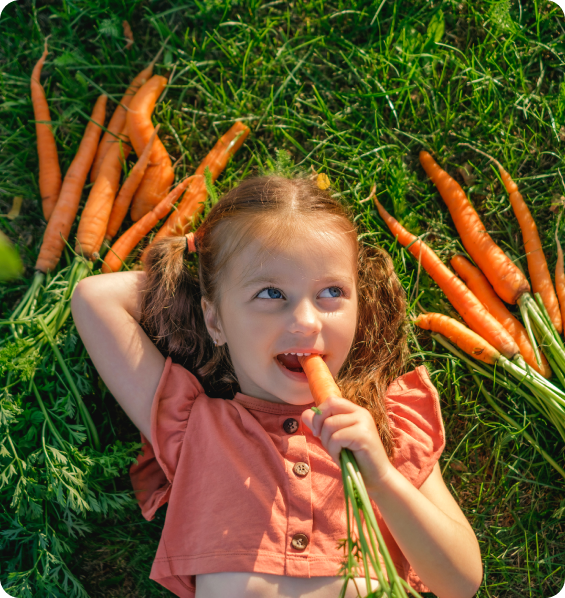 Child holding and eating a carrot