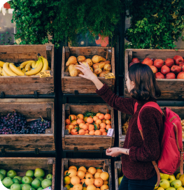 Shopper choosing produce at a fruit and vegetable stall