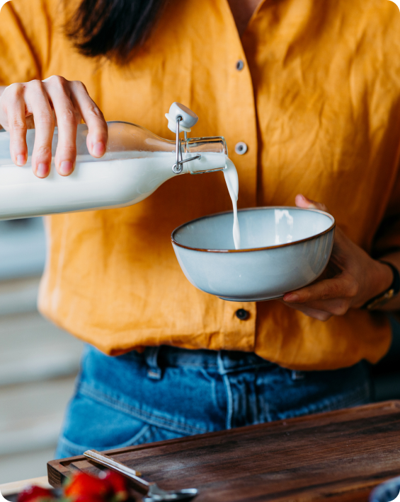 Person pouring milk into a cereal bowl