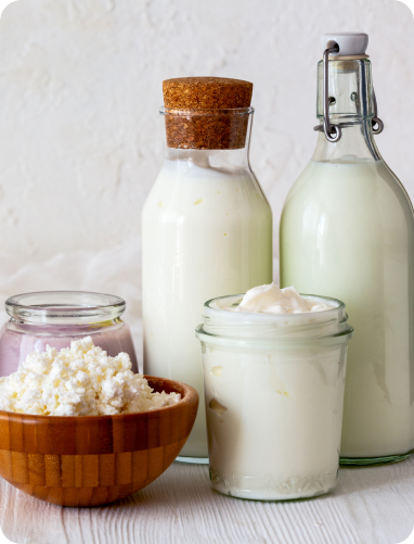 Milk bottles and a glass beside a jar of honey