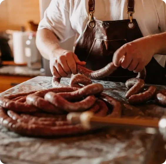 A butcher shaping sausages by hand