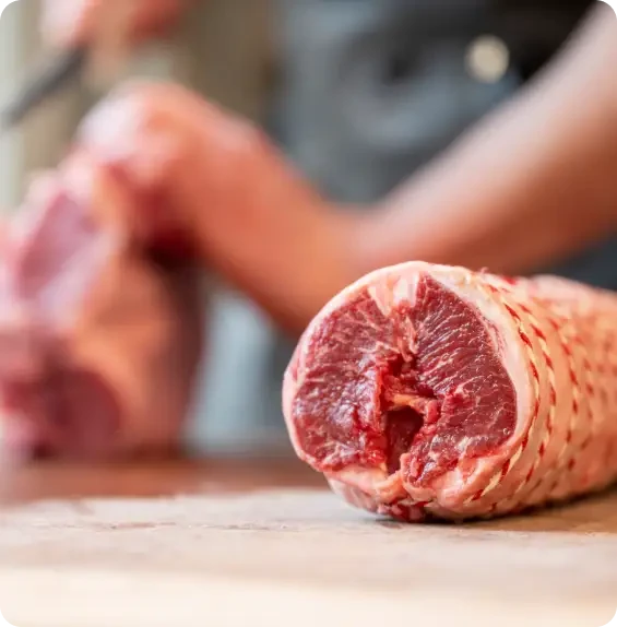 A rolled joint of raw meat held in netting