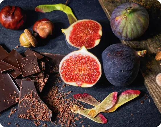 Whole and halved figs beside chocolate and nuts