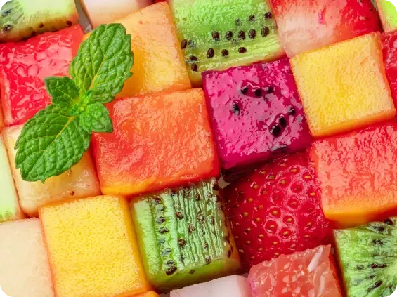 Colourful cubes of fresh fruit arranged with mint leaves