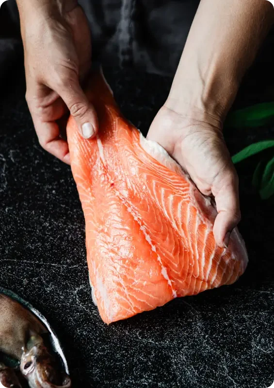 Hands holding a raw salmon fillet