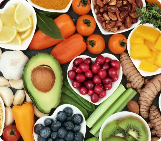 Fruit, vegetables and nuts arranged together on a pale surface