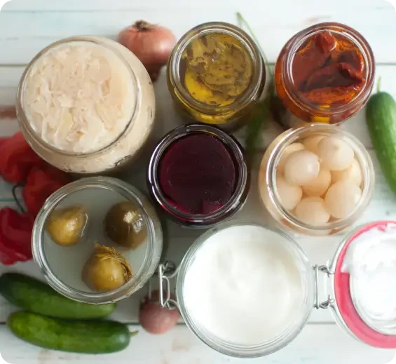 Open jars and bowls of preserved vegetables, eggs and dairy foods