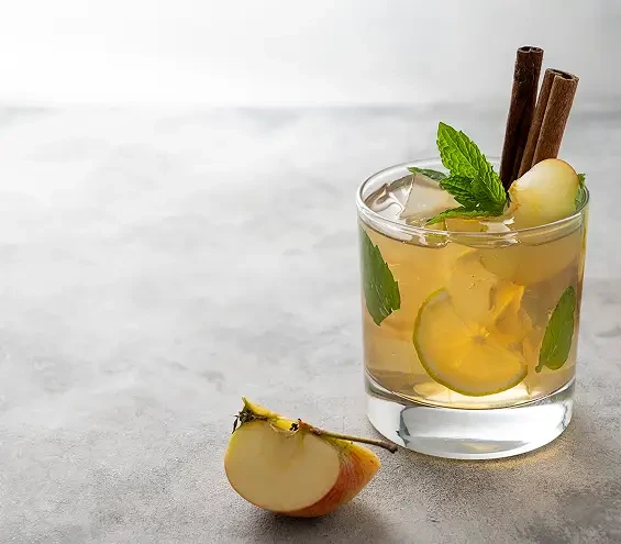 An apple drink garnished with mint and cinnamon sticks