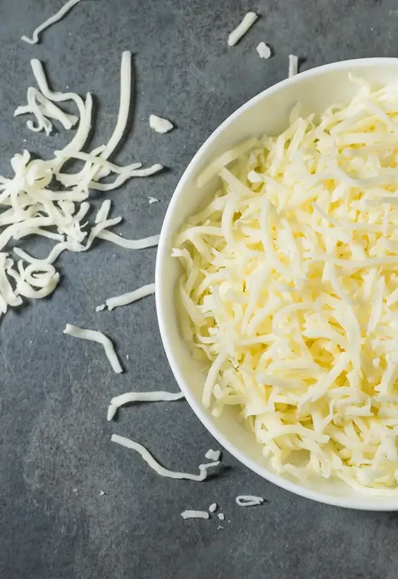 Grated pale cheese in a white bowl