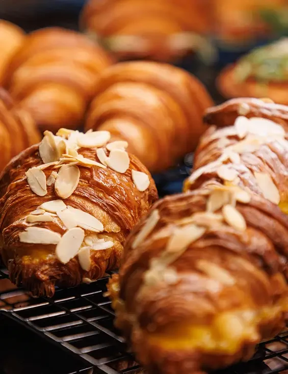 Almond-topped pastries cooling on a wire rack