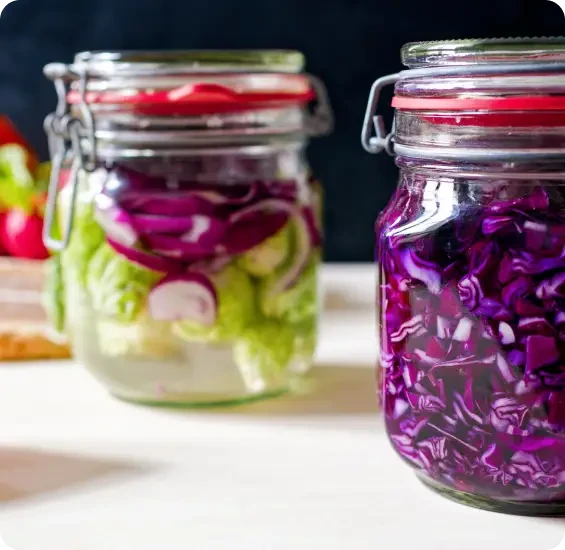 Two jars filled with layered green and purple vegetables