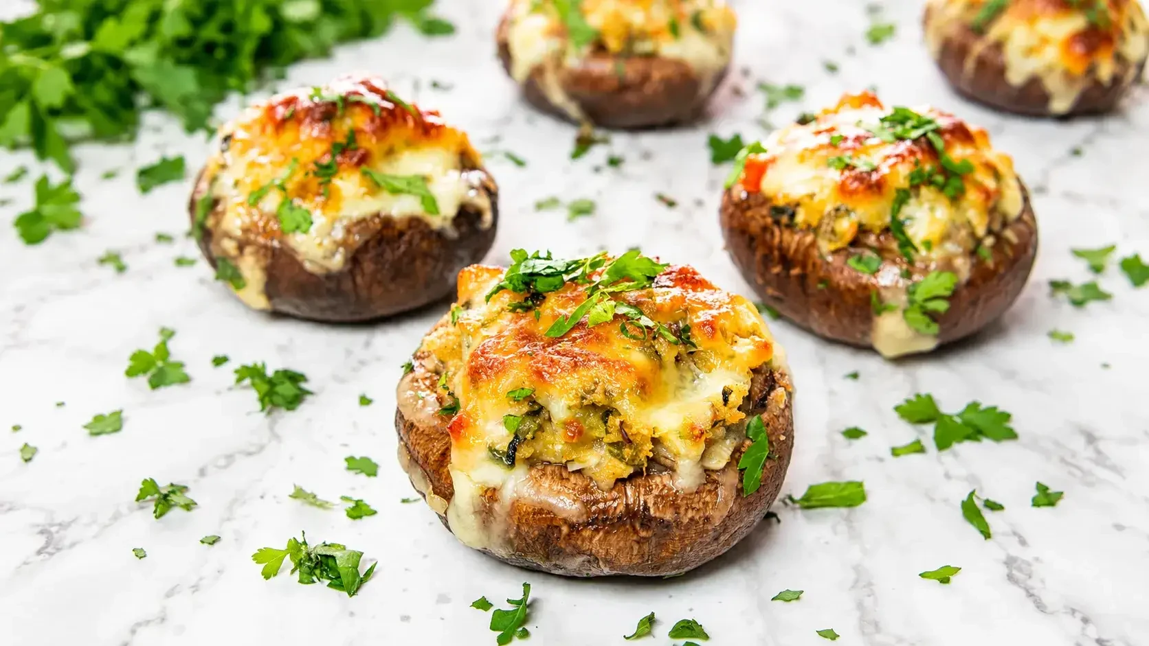 Baked stuffed mushrooms topped with melted cheese and herbs