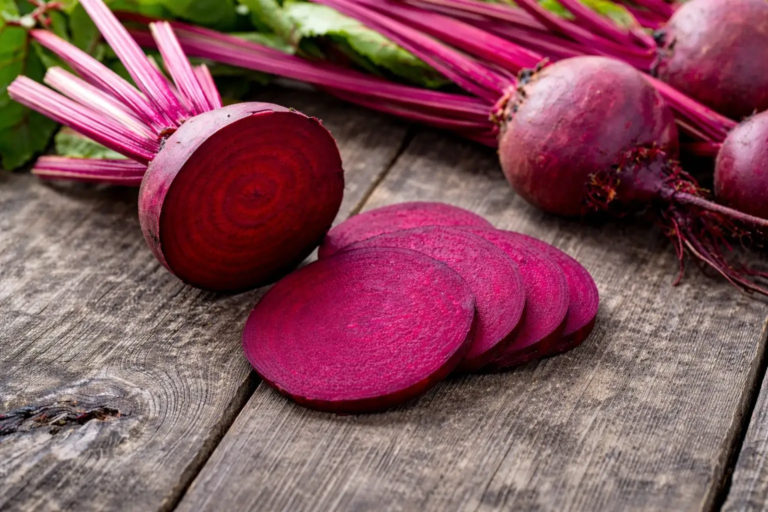 Whole and sliced beetroot with leafy stems