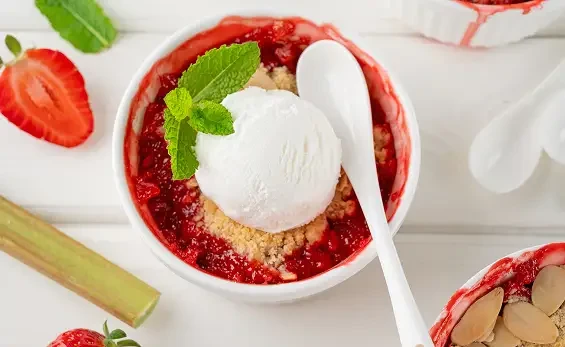 A fruit dessert topped with a scoop of ice cream and mint