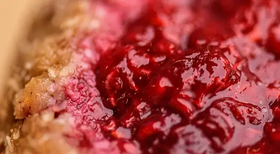 Close view of red berry jam spread on bread