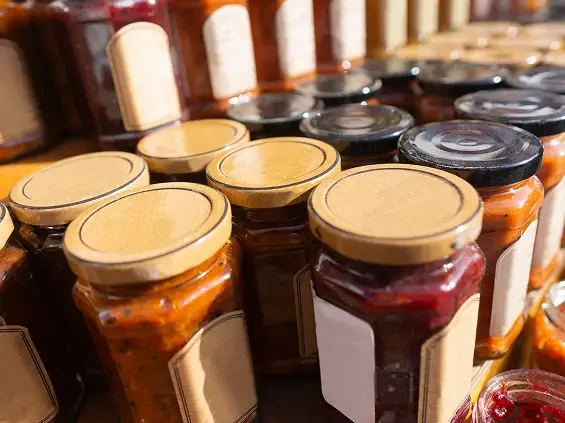 Jars of different preserves with blank labels and metal lids