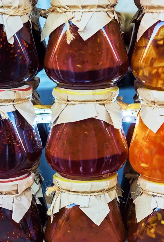 Stacked jars of colourful preserves with paper covers