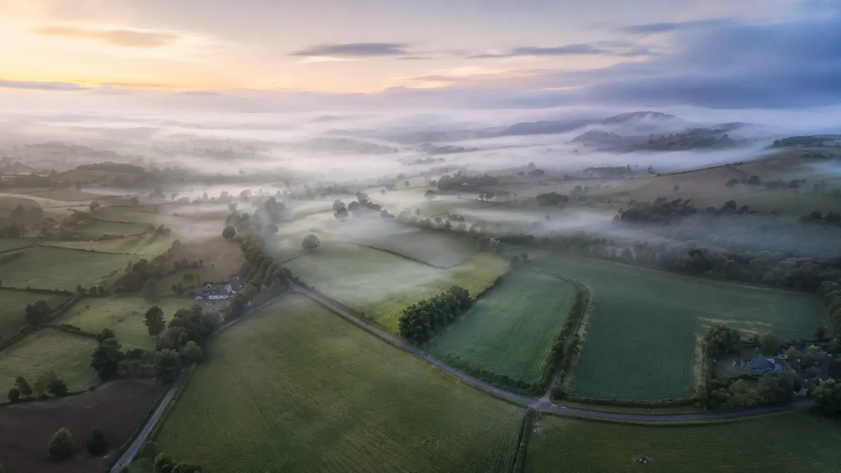 Aerial view of fields and hedgerows in morning mist