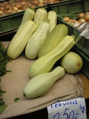 Pale green elongated marrows on a market stall