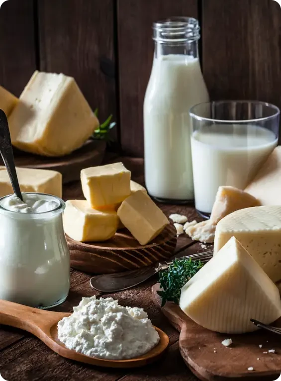 Milk, butter and a selection of cheeses on a wooden table