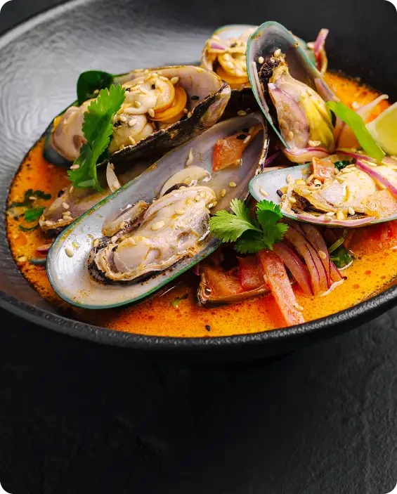 Mussels and other shellfish served in a rich orange sauce