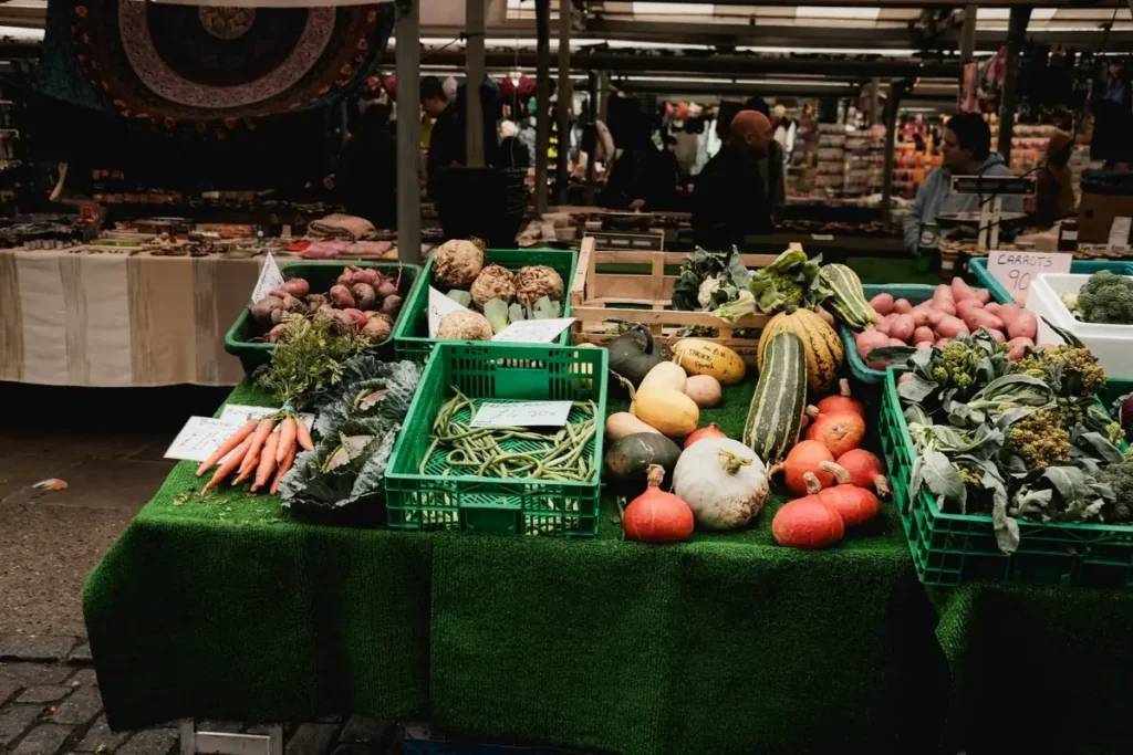 Fresh organic vegetables displayed in green crates at a market stall