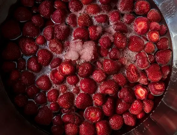 Strawberries and sugar in a saucepan