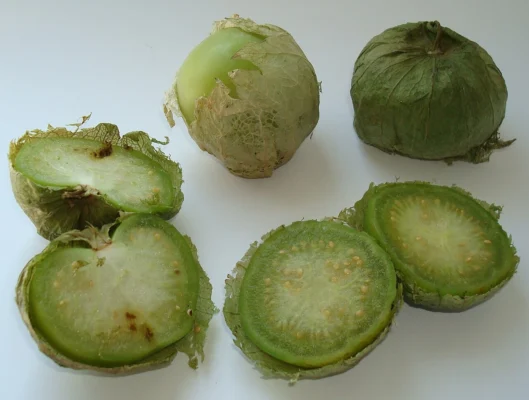 Whole and cut tomatillo fruits showing pale flesh and many small seeds