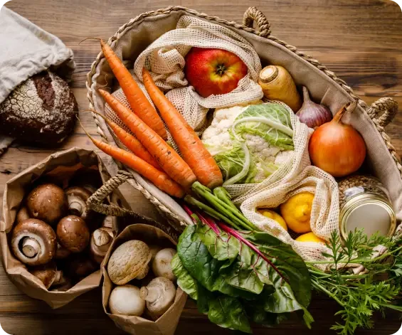 Reusable bags and baskets filled with fresh vegetables and bread